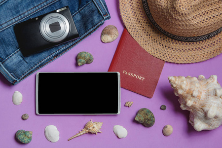 护照, 牛仔裤, 相机, 帽子, 智能手机, 海贝在丁香的背景。热门旅游概念模拟