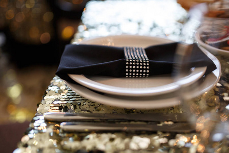 美丽的装饰, 豪华的婚宴在复古风格的餐厅。用镶有水钻的亮片盘子餐具酒杯和餐巾用闪亮的桌布服务餐桌
