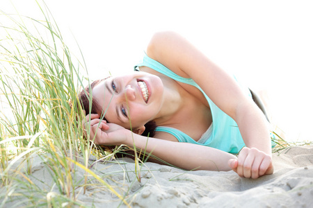 无忧无虑的年轻女人躺在海滩上