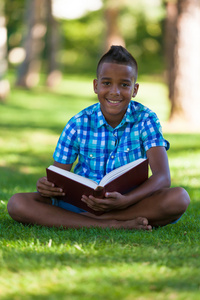 学生黑色男孩读一本书非洲 p 的室外肖像