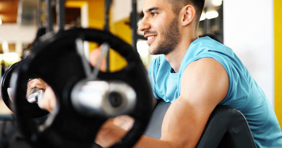 在健身房做二头肌肌肉健美锻炼锻炼与酒吧