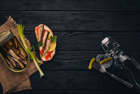 伏特加和一套三明治与鲱, 鱼子酱, 洋葱和欧芹, 在一个木制的背景。顶部视图。复制空间