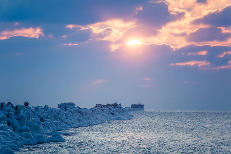 波罗的海一座冰冻防波堤的美丽夜景。海滩上的冬季景观。生动的色彩