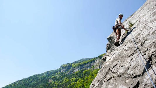 在一个美丽的日子在瑞士的阿尔卑斯山上的岩石攀登者在一条板石灰石上升的路线
