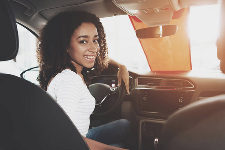 非洲裔美国妇女坐在汽车经销商的新汽车沙龙