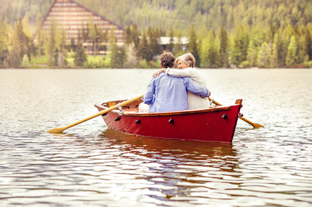 在小船上划桨的年长夫妇