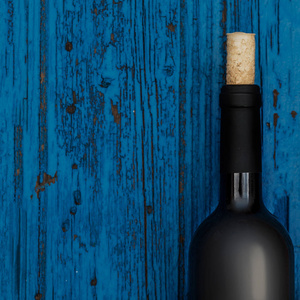 瓶酒在蓝色木背景与 copyspace, 酒品尝概念