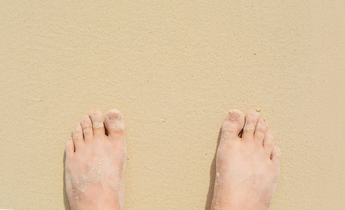 关闭在海沙上的脚的看法。暑期理念