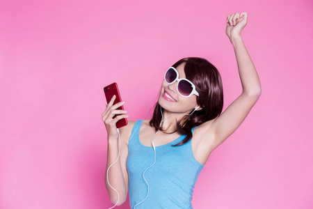 妇女使用电话和听音乐在粉红色背景
