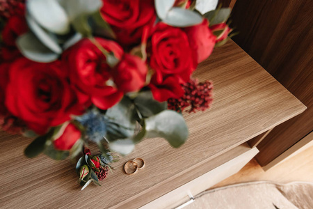 美丽的图片与结婚戒指躺在一个木质的表面上, 一束花的背景