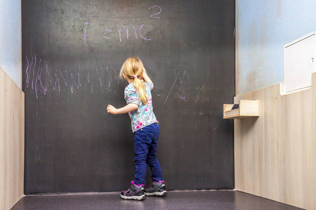 可爱的小女孩，在黑板上书写