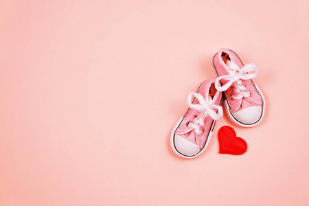 粉红色背景的婴儿运动鞋