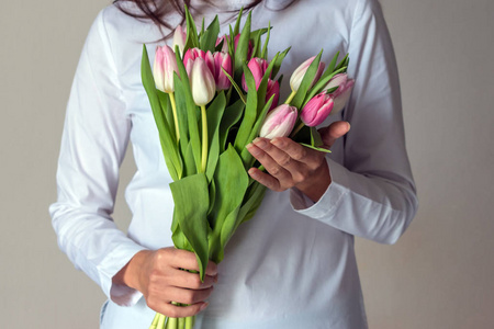 粉红色郁金香的春天花束在妇女的手