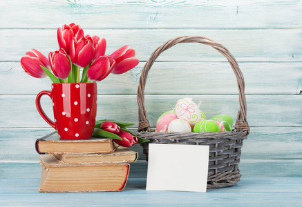 红郁金香花束和复活节彩蛋在木墙前。复活节贺卡