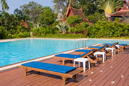 游泳池和日光浴浴床在泰国的热带花园