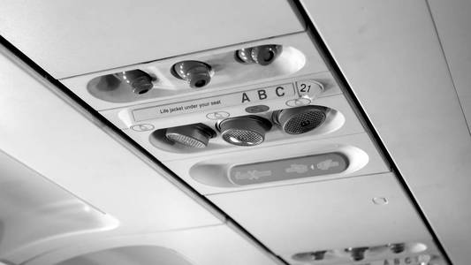喷气飞机天花板上乘客控制面板的黑白图像