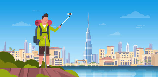 男子游客与背包带自拍照片在美丽的迪拜城市背景