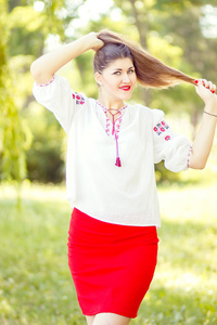 户外时尚棕色的头发的女人肖像绣乌克兰民族服装。美丽的女子和亮妆构成的性质
