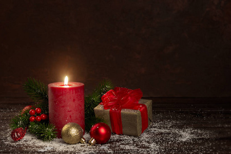 红色蜡烛礼品盒与丝带圣诞新年装饰品在雪暗背景
