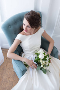 有魅力的新娘, 婚礼花束坐在扶手椅上
