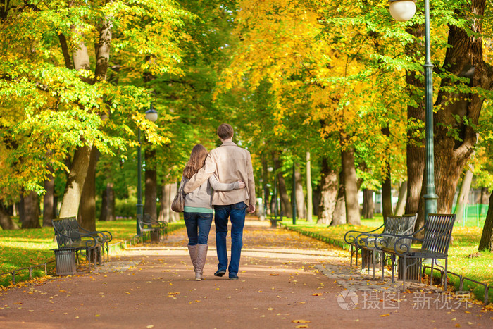 在秋天的一天在公园里一起散步的夫妇
