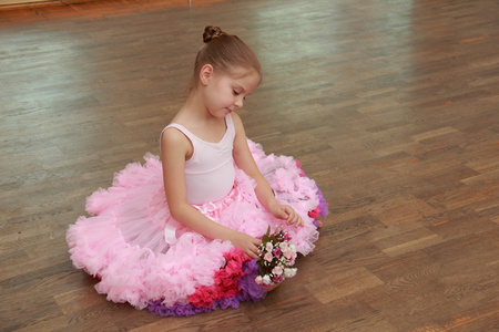 坐在硬木地板上美丽茂盛舞蹈裙子迷人儿童
