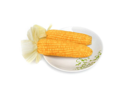 在白色背景的盘子上煮的玉米图片