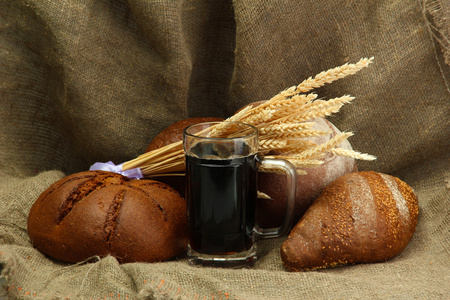 坦卡的格瓦斯和黑麦面包用粗麻布背景上的耳朵
