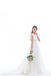 漂亮的新娘摆在传统的白色礼服与婚礼花束, 孤立的白色