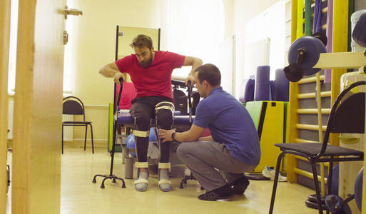 医生理疗师将矫形器放在残疾人身上