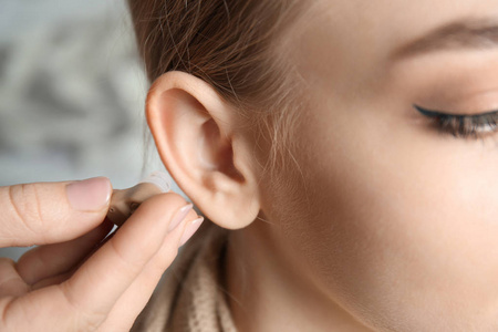 医生把助听器在妇女的耳朵, 特写