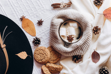 秋季和冬季作文。热咖啡与棉花糖, 围巾, 饼干, 帽子, 颠簸和秋天的叶子。平躺, 顶部视图