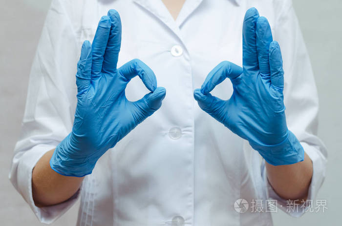 护士在医疗礼服和在手上的医疗手套显示一个好的手势.良好的治疗效果