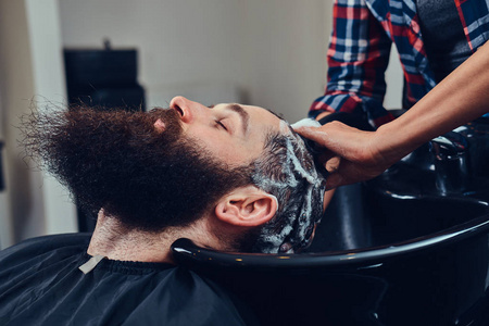 专业美发师在理发店洗客户头发