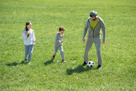 儿童与父亲在公园踢足球