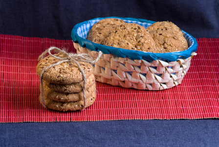自制燕麦曲奇饼, 配以葵花籽和后蓝色格子篮在木桌上