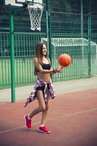 美丽的年轻女子在户外篮球