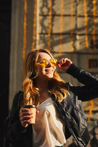 漂亮女孩站在街上喝着咖啡