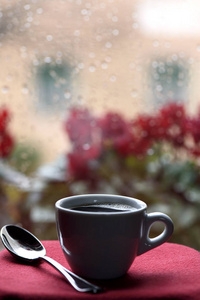 一杯热咖啡在窗前的雨滴