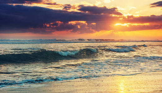 在海滩上的蓝色波浪。模糊背景和阳光的斑点。和平的自然背景