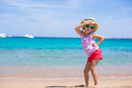 可爱的小女孩在洁白的沙滩上玩得开心