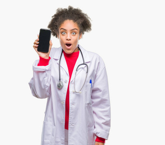 年轻的美国黑人医生妇女使用智能手机在孤立的背景下吓坏了惊讶的脸, 害怕和兴奋的表情恐惧