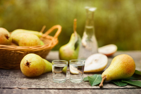 梨白兰地酒在木桌上成熟梨的玻璃杯