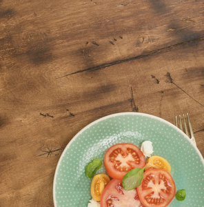 意大利沙拉配有西红柿和芝士乳酪在深色木桌上, 带有复制空间, 顶部视图