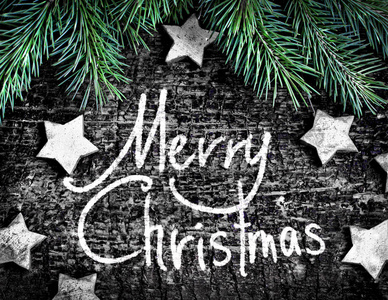 圣诞快乐题字灰色木背景与星和冷杉分支