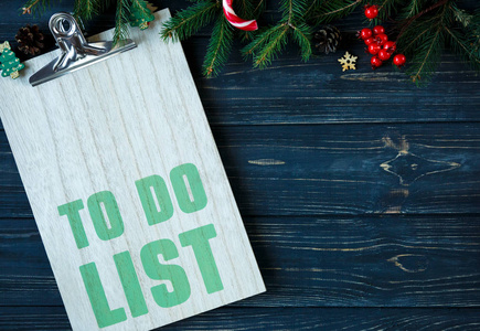 在木垫和杉木树枝上做列表, 装饰在灰色的木桌上。新年目标列表, 事情做圣诞节的概念。平躺与 copyspace