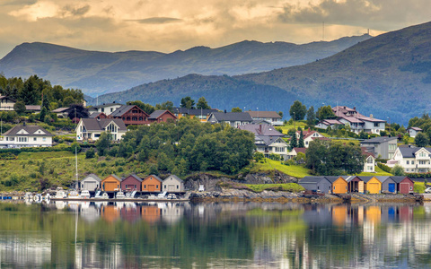 在挪威 Ulsteinvik 附近的风景秀丽的峡湾海岸线上的风景如画的村庄家船屋