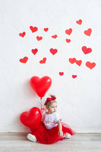 可爱的孩子, 带着红色的心。快乐的小女孩用红色气球在一堵空白的砖墙上。婚礼, 情人节概念