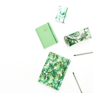 笔记本, 铅笔和铅笔盒在异国情调的热带棕榈风格白色背景。平躺, 顶部视图最小艺术家概念