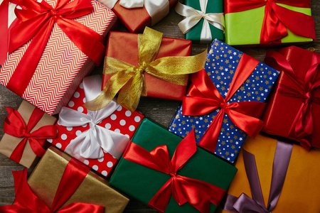 平躺在圣诞礼物包裹在不同的包装纸与丝带在木表面图片